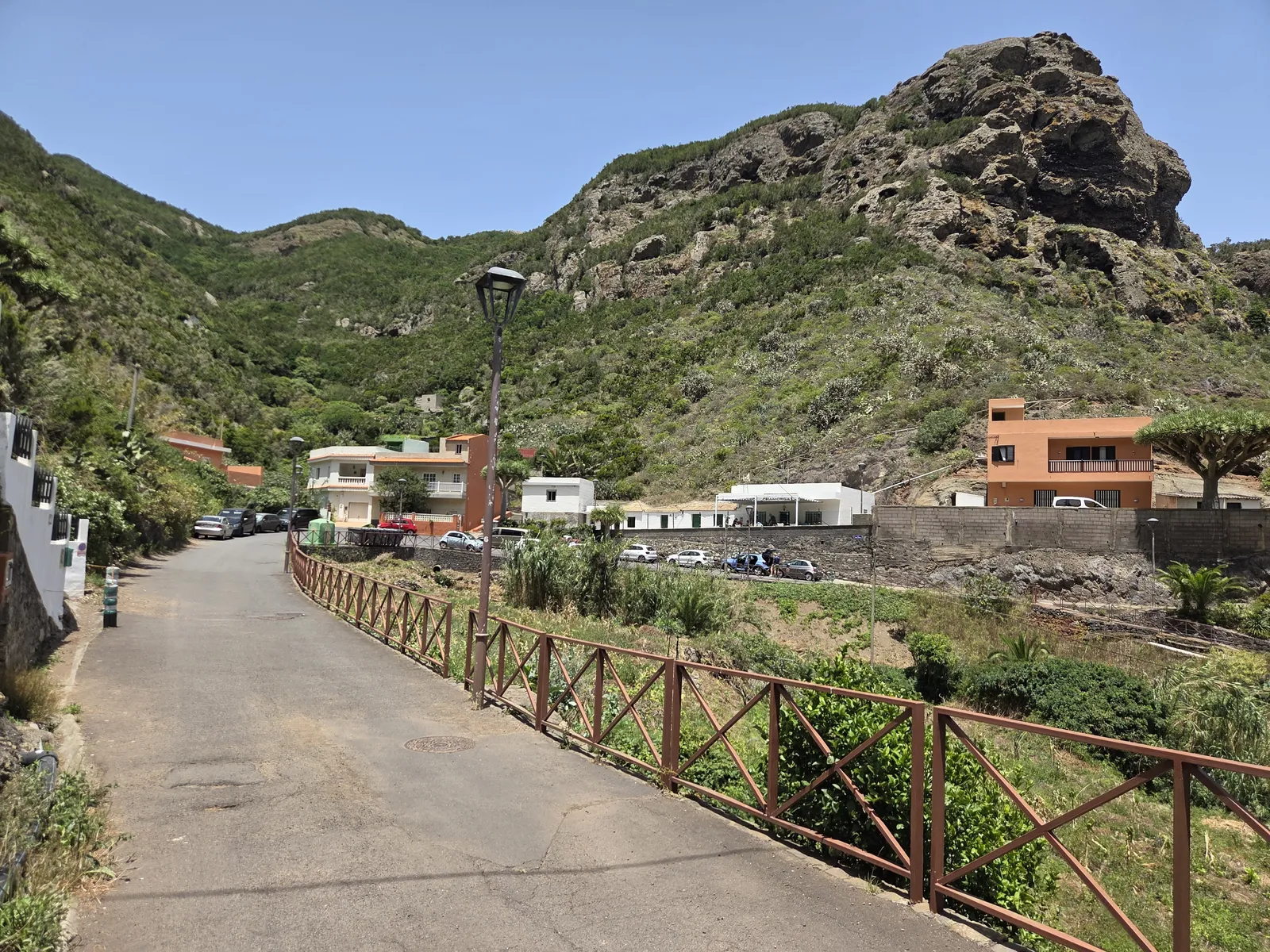 Camino de Chamorga junto a huertas, viviendas y paredes rocosas