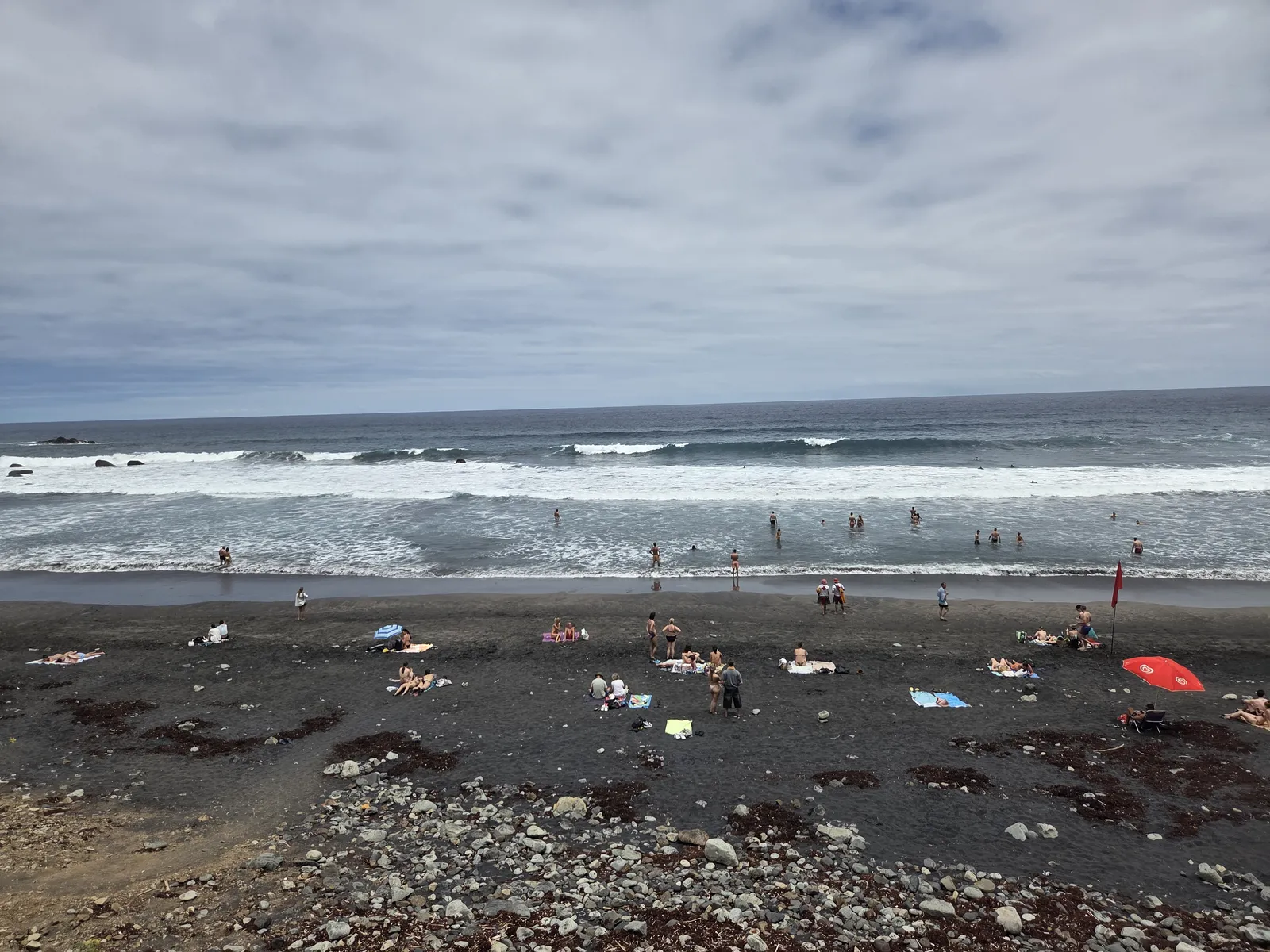 Playa de Almáciga con arena negra, bañistas y oleaje atlántico