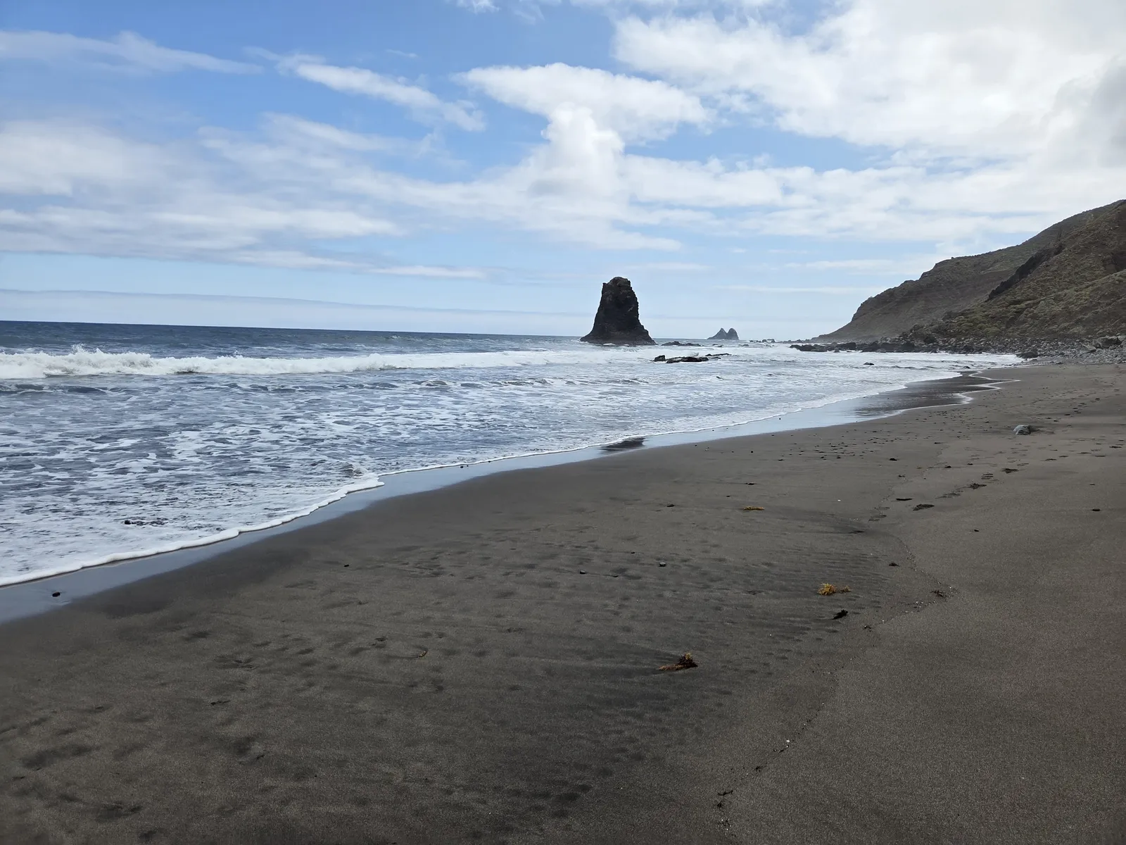 Playa de Benijo con arena negra, oleaje atlántico y roques frente a la costa