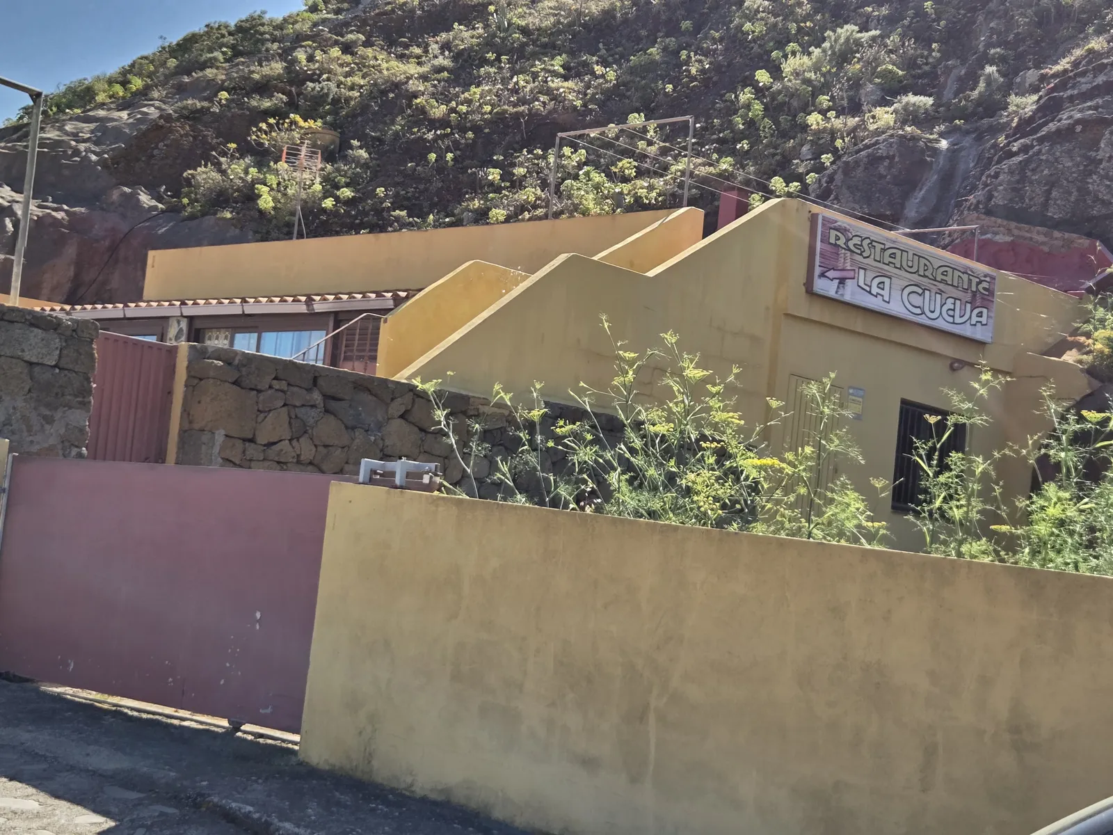 Exterior del Restaurante La Cueva integrado en una ladera rocosa de Chinamada